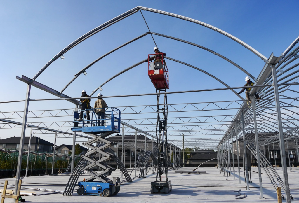 Montage de l'ossature d'acier à arche gothique d'une serre multichapelle Luminosa
